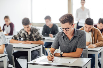 Group of high school students having test at classroom.